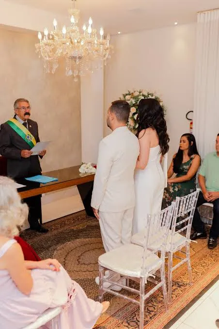 Casal diante do celebrante durante a leitura da cerimônia de casamento civil
